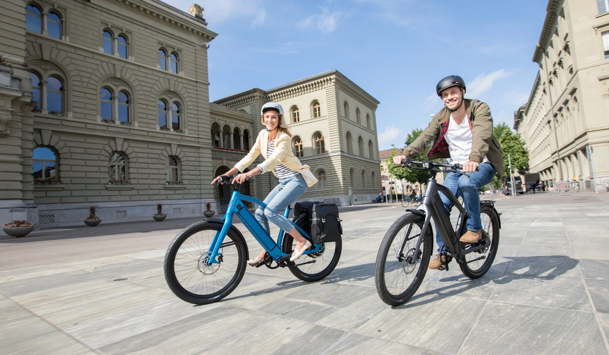 Couple avec des vélos électriques Stromer ST2 royal blue et dark grey pendant un déplacement en ville.