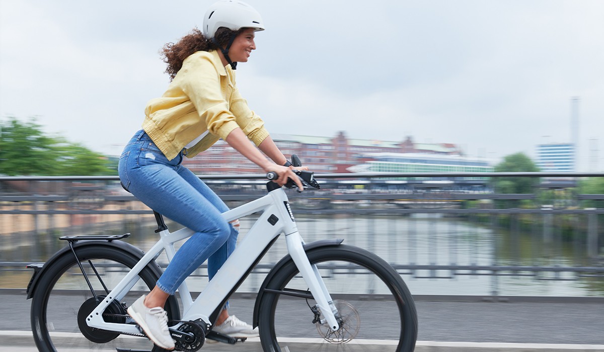 Des déplacements en tout confort : une femme roule sur son ST3 avec une position de conduite personnalisable.