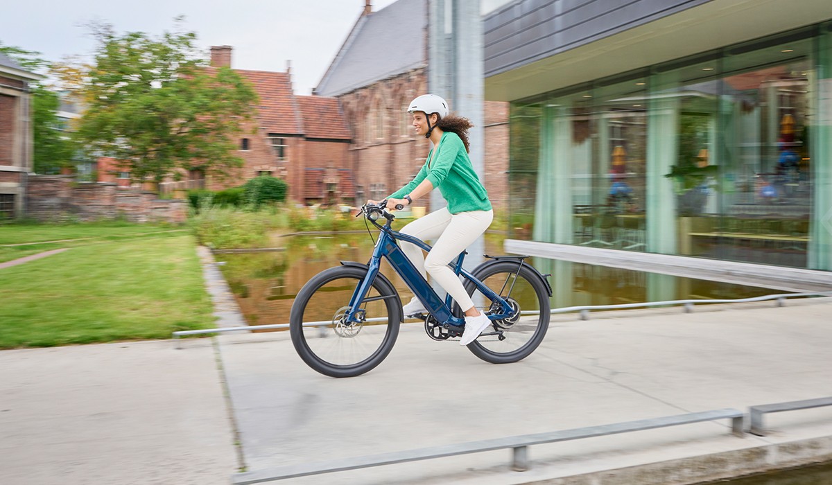 Femme chevauchant le vélo électrique Stromer ST1 avec assistance motorisée jusqu'à 45 km/h.