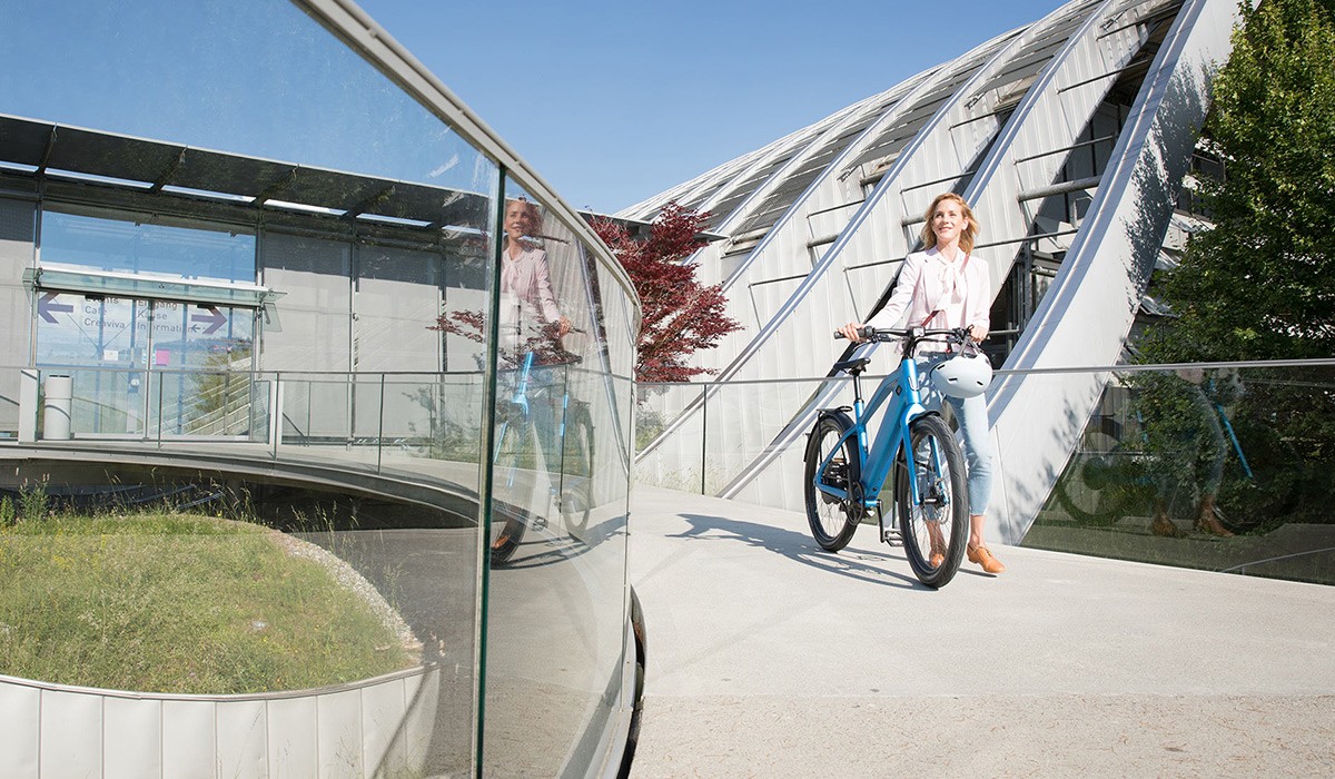 Déplacements sereins et sûrs avec une assurance vélo électrique : une femme avec son vélo électrique Stromer.