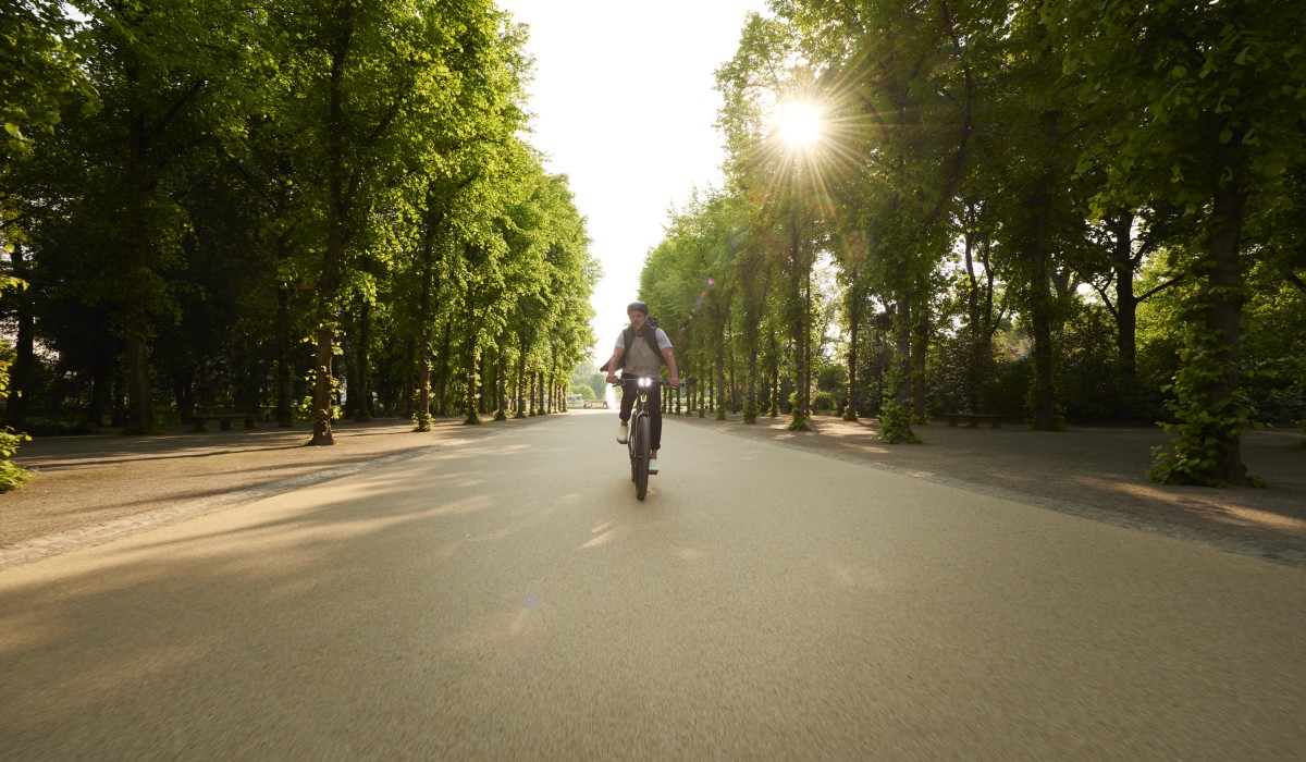 Man riding a Stromer ST7 Speed Pedelec on lane with trees, sun going down