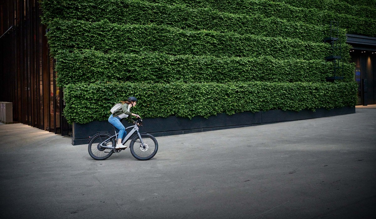 Une femme roule avec son ST1 le long d'un mur rempli de graffitis. 